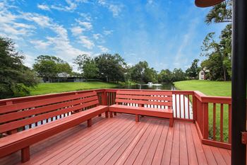 A large wooden bench on a deck
